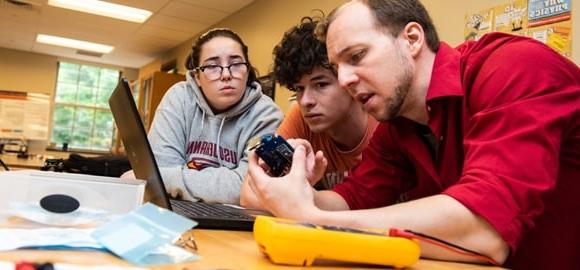 Two students working with a faculty member